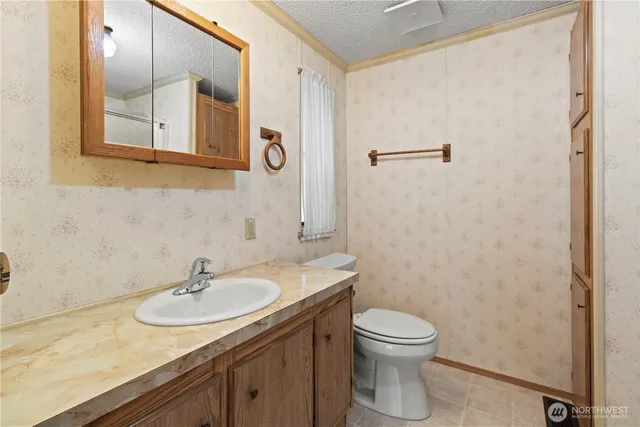 a bathroom with a granite countertop sink toilet and a mirror