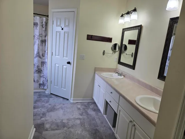 a spacious bathroom with a double vanity sink and mirror