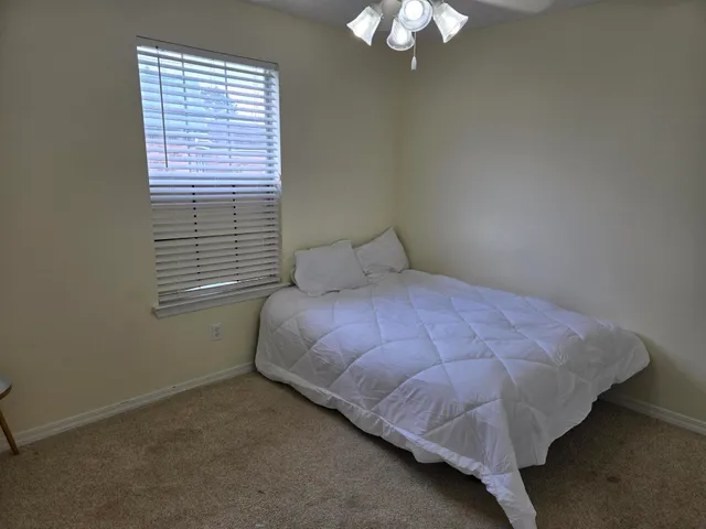 a bed sitting in a bedroom next to a window