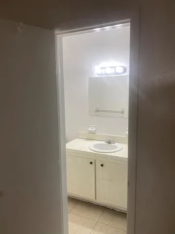 a bathroom with a sink a light fixture and a mirror