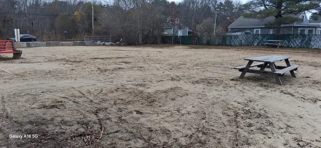 a view of a backyard with table and chairs with wooden fence