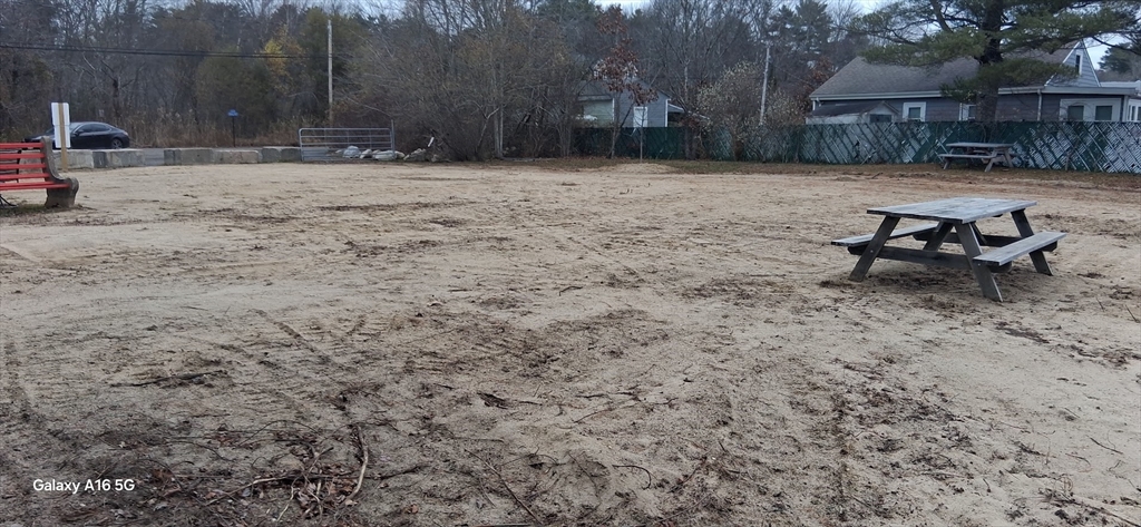 0 Island Road Lakeville, MA 02347 - Photo 3 of 8 a view of a backyard with table and chairs with wooden fence