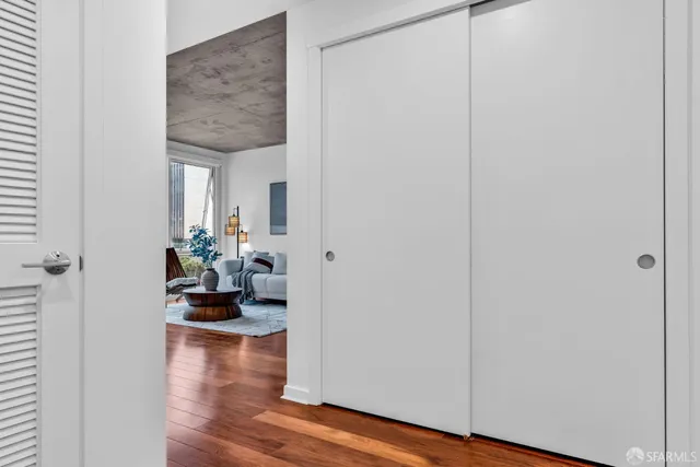 a view of a hallway with wooden floor and a potted plant