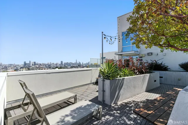a view of a roof deck with couches and potted plants