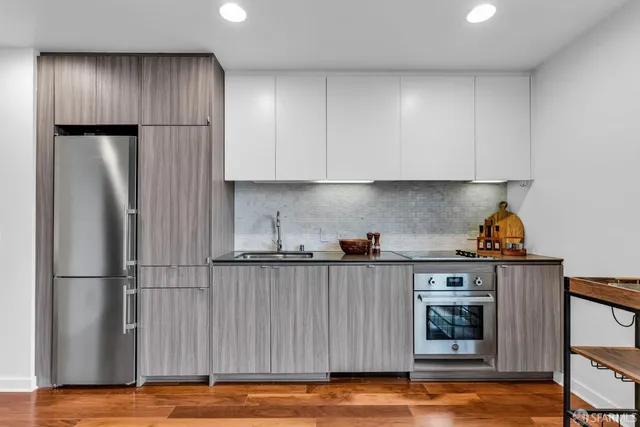 a kitchen with stainless steel appliances granite countertop a refrigerator and a stove top oven