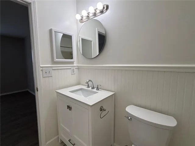 a bathroom with a toilet sink and mirror