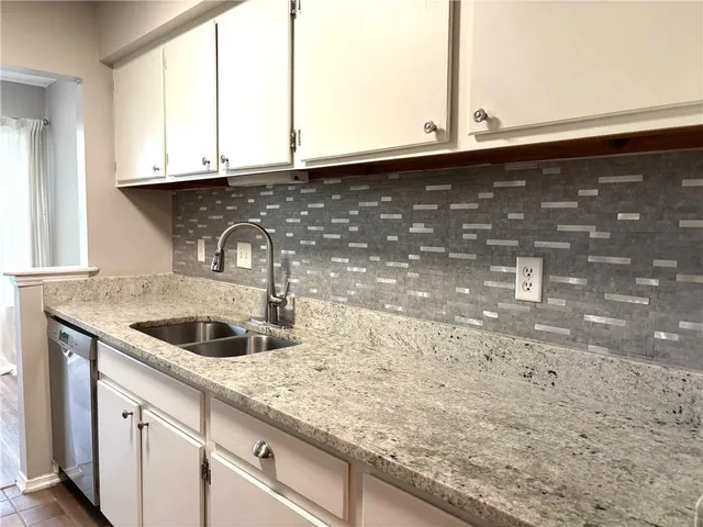 a kitchen with granite countertop a sink and a window