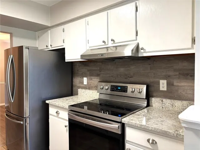 a kitchen with a stove a refrigerator and a sink