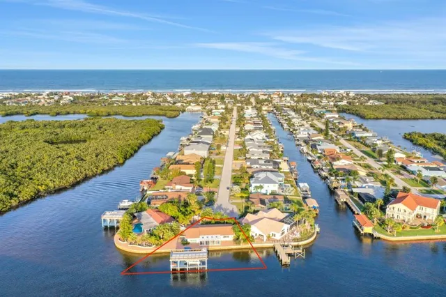 an aerial view of ocean and residential houses with outdoor space