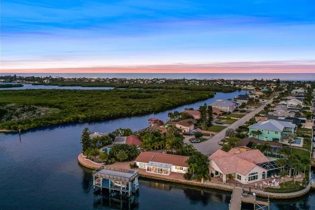 an aerial view of ocean and residential houses with outdoor space