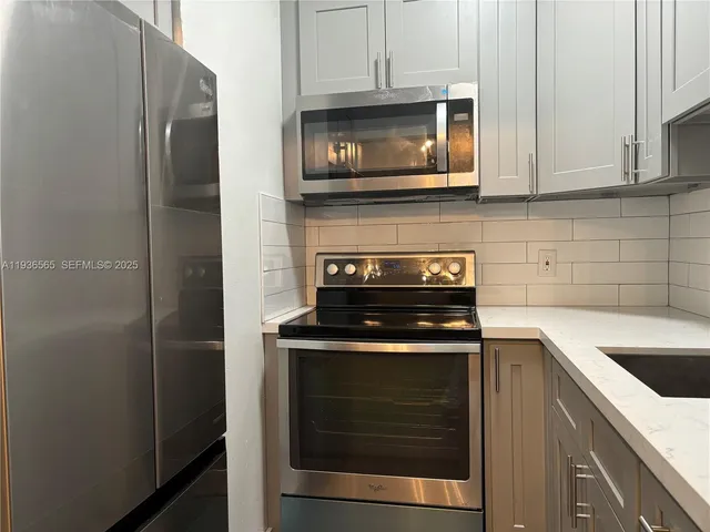 a kitchen with stainless steel appliances granite countertop a stove and a microwave