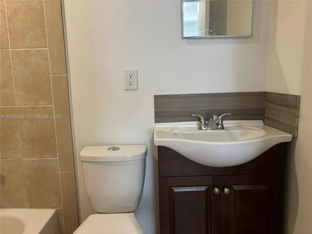 a bathroom with a sink toilet and a mirror
