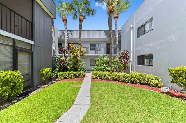 a front view of a house with a yard and potted plants