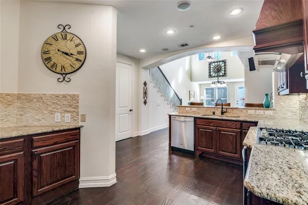 a kitchen with stainless steel appliances granite countertop a stove and a wooden floors