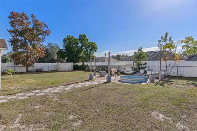 a view of backyard with swimming pool and seating space