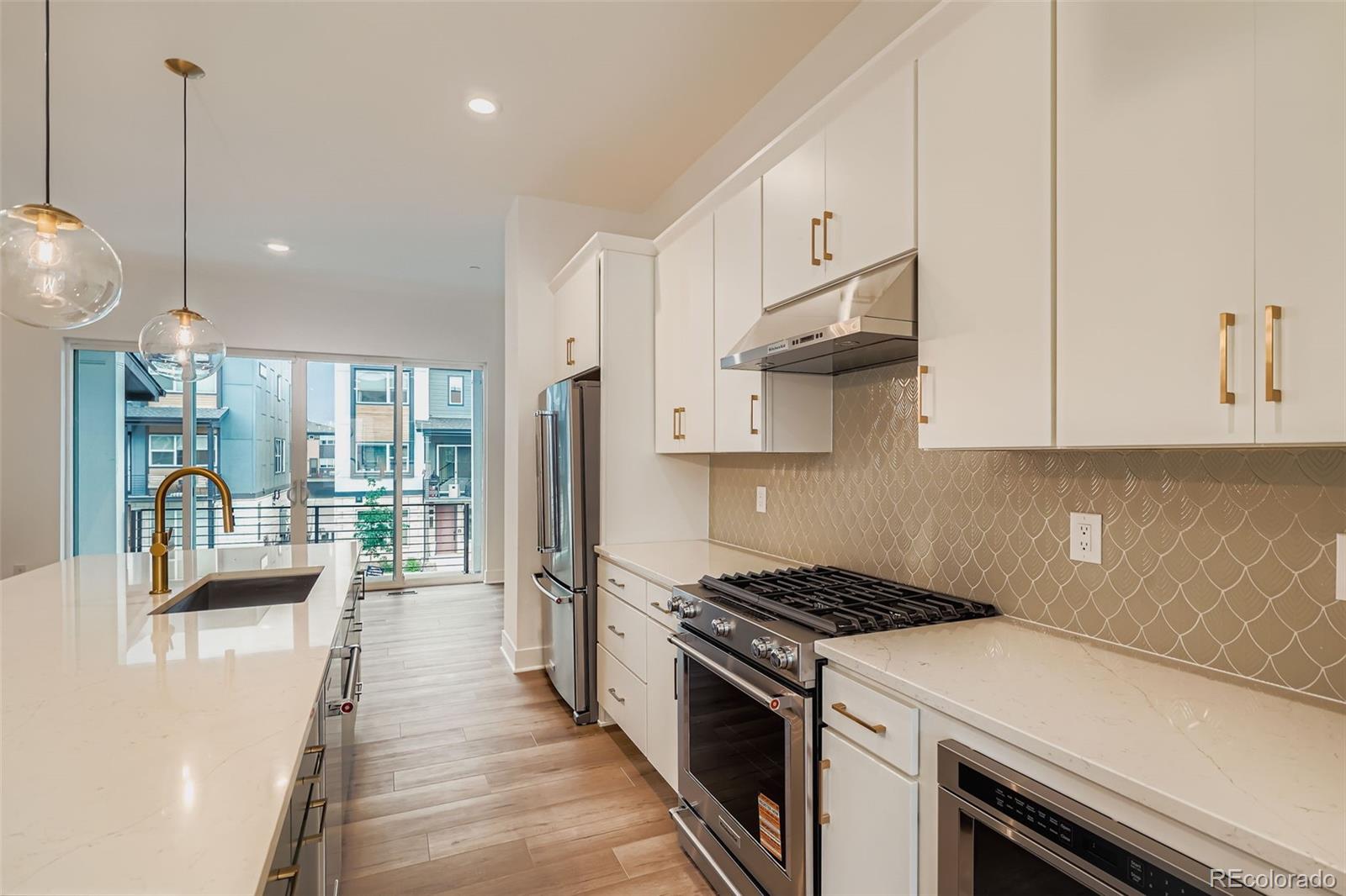 765 Superior Drive Superior, CO 80027 - Photo 13 of 32 a kitchen with stainless steel appliances granite countertop a stove a sink dishwasher and a refrigerator with wooden floor