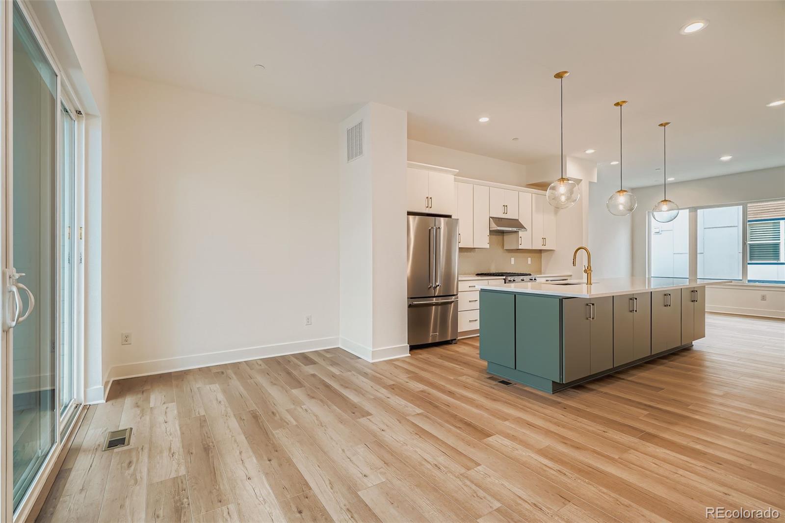 765 Superior Drive Superior, CO 80027 - Photo 8 of 32 a kitchen with stainless steel appliances kitchen island wooden floors wooden cabinets and entryway