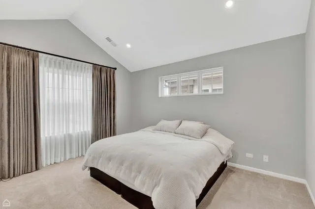 a bedroom with a large bed and a window