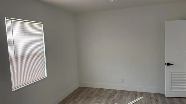 a view of a small space with wooden floor and a window