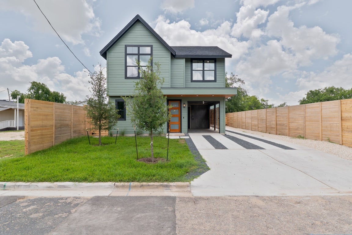 a front view of a house with a garden and plants