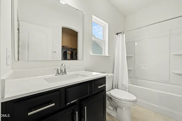 a bathroom with a sink a toilet a mirror and shower