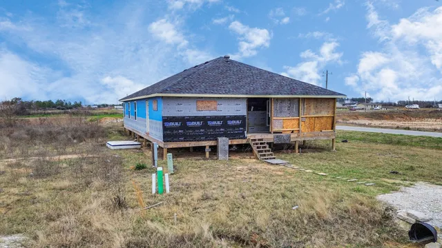 a backyard of a house with barbeque oven table and chairs