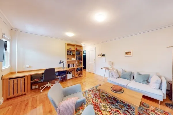 a living room with furniture a rug and a table