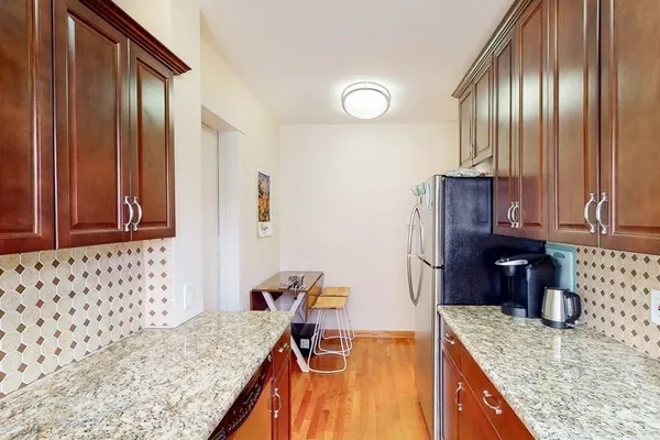 a kitchen with granite countertop a sink a stove and a refrigerator