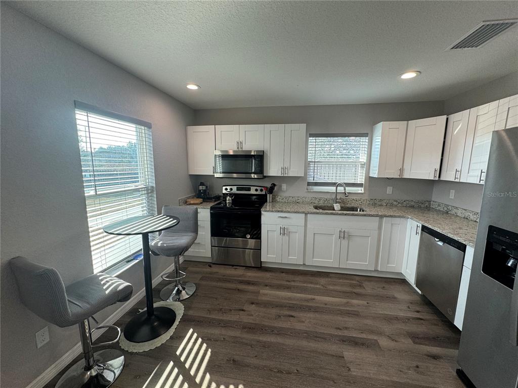 13183 Southwest 113th Place Dunnellon, FL 34432 - Photo 15 of 22 a kitchen with a sink wooden cabinets and dining table chair