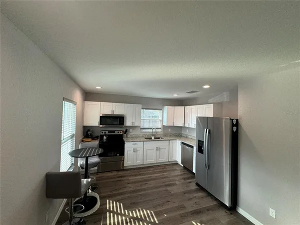 a kitchen with granite countertop a stove a sink and a microwave