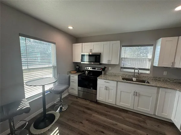 a kitchen with stainless steel appliances granite countertop a refrigerator stove microwave and sink