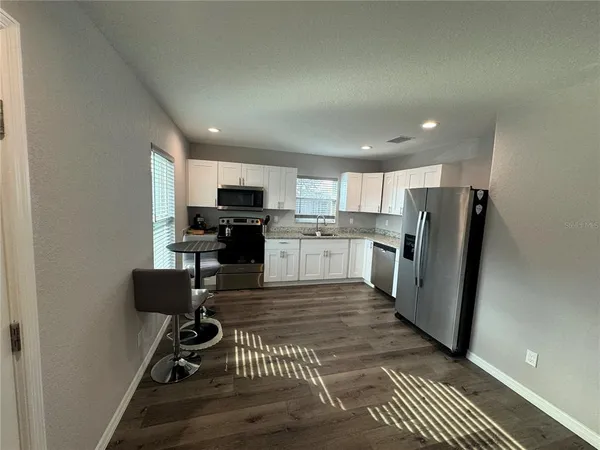 a kitchen with a refrigerator and a stove top oven