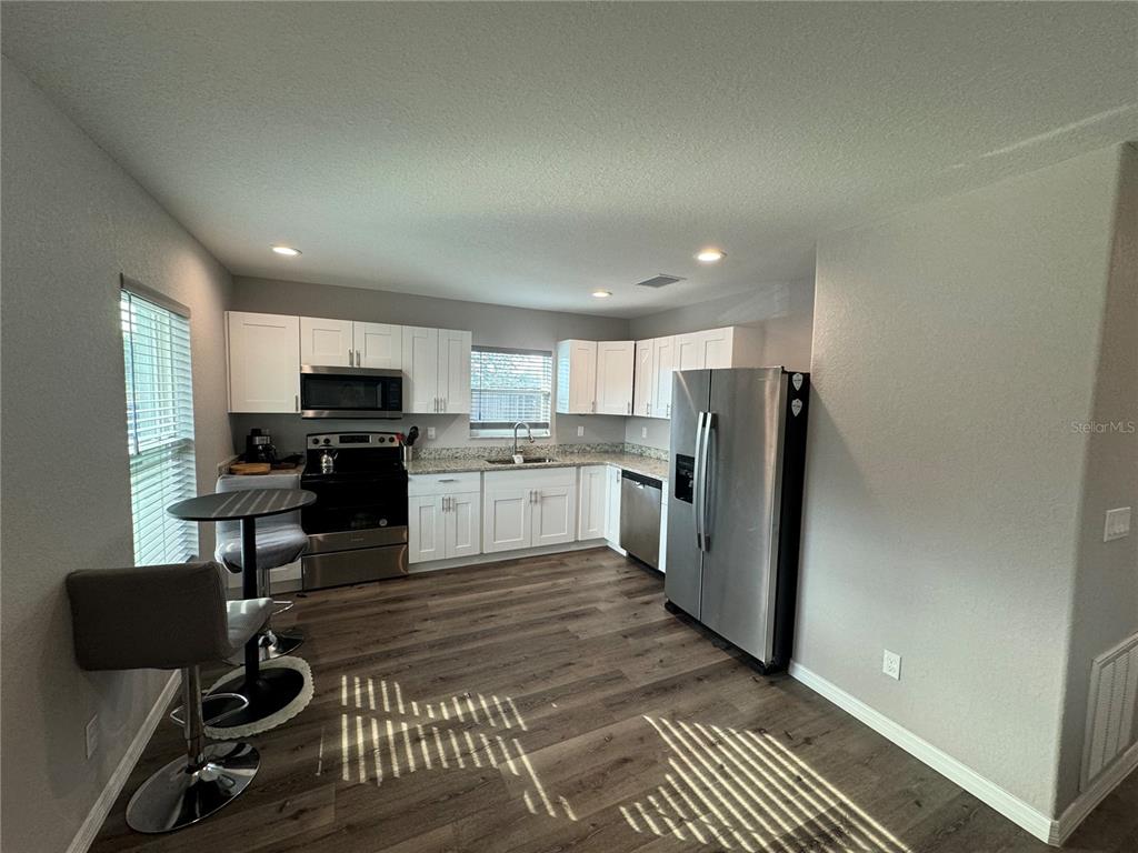 13183 Southwest 113th Place Dunnellon, FL 34432 - Photo 21 of 22 a kitchen with a refrigerator and a stove top oven