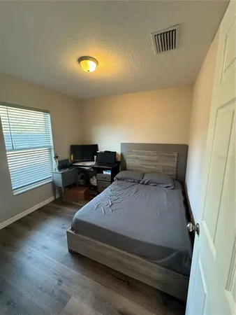 a bedroom with a bed and wooden floor