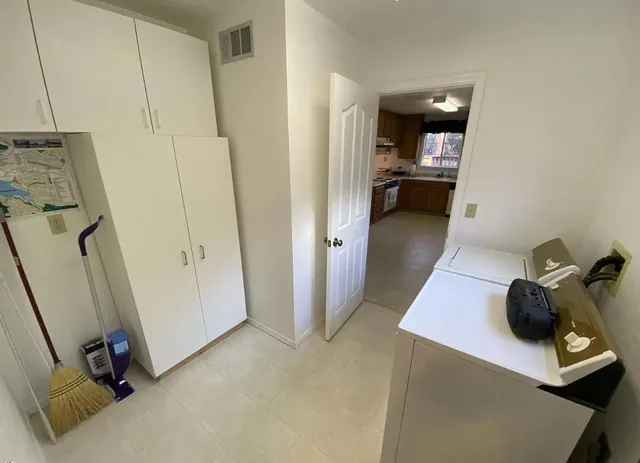 a view of a hallway with workspace and a couch