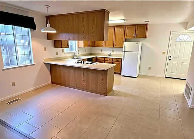 a kitchen with stainless steel appliances a sink a stove a refrigerator and cabinets