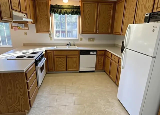 a kitchen with a stove a refrigerator and a sink