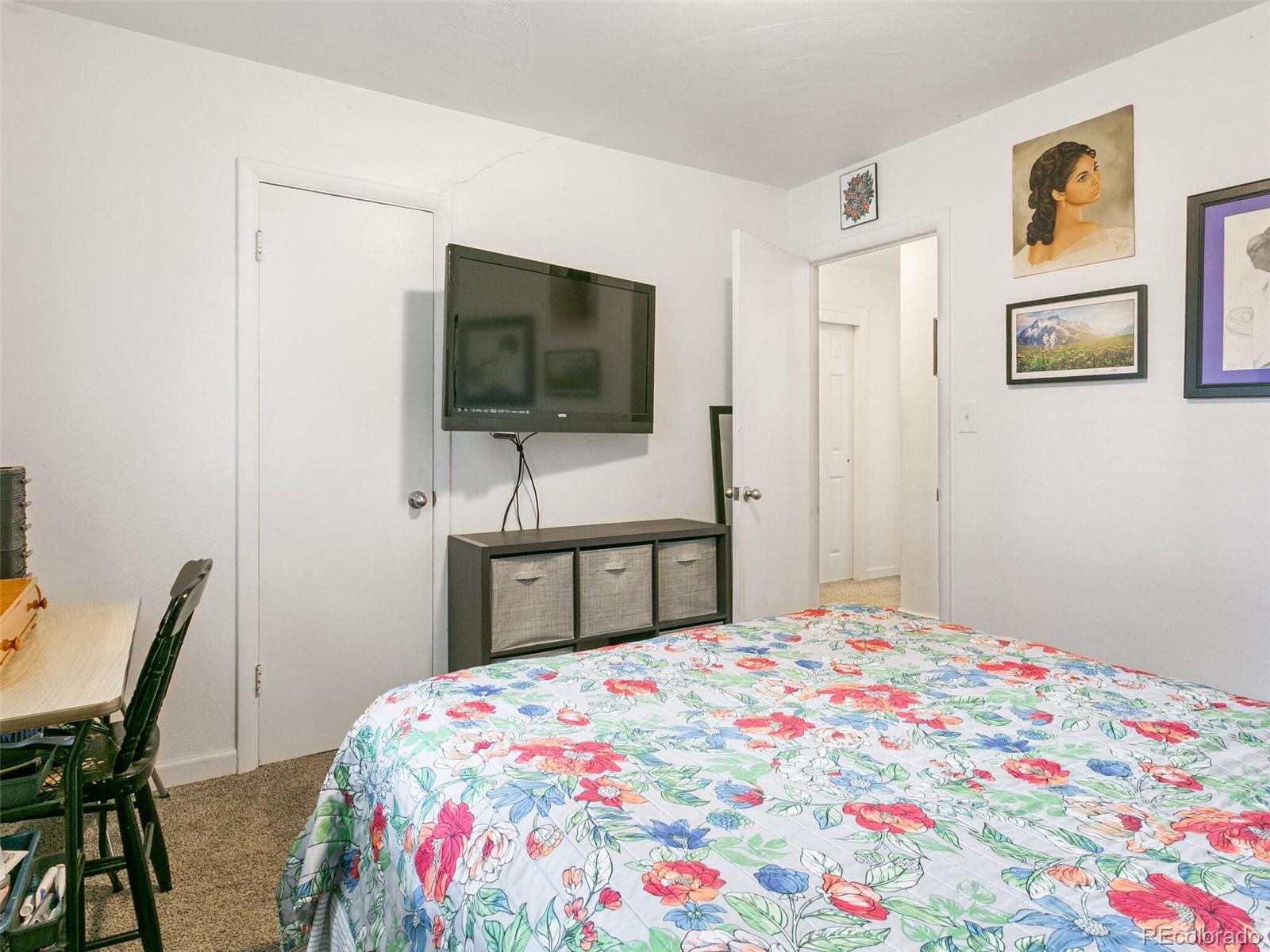 4615 Field Street Wheat Ridge, CO 80033 - Photo 14 of 39 a bedroom with a bed and a flat screen tv
