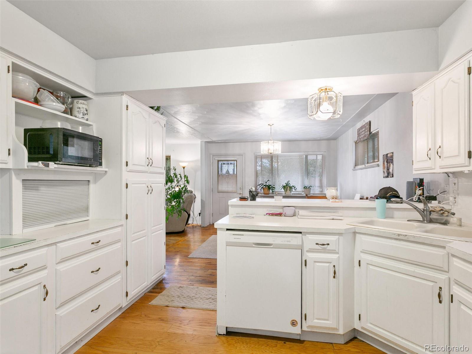 4615 Field Street Wheat Ridge, CO 80033 - Photo 26 of 39 a kitchen with white cabinets and sink