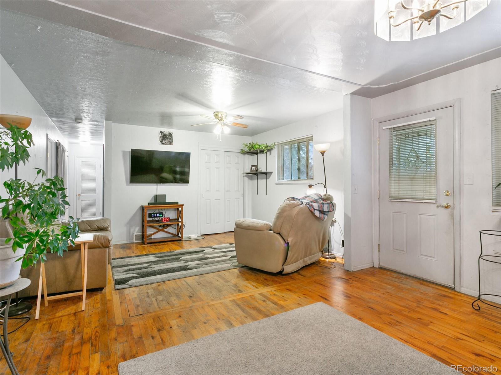 4615 Field Street Wheat Ridge, CO 80033 - Photo 27 of 39 a living room with furniture and a flat screen tv