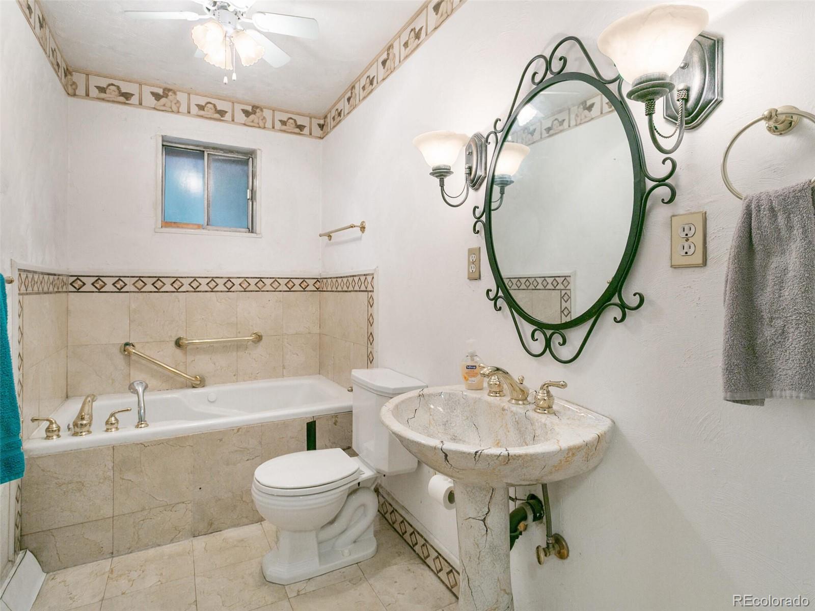 4615 Field Street Wheat Ridge, CO 80033 - Photo 34 of 39 a bathroom with a sink a mirror a toilet and a mirror