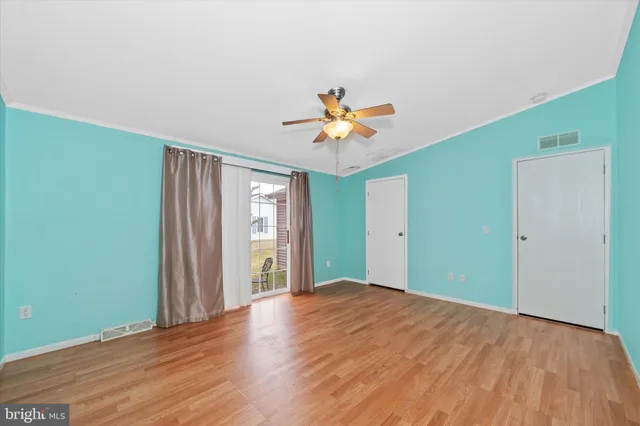 a view of a big room with wooden floor and a chandelier fan