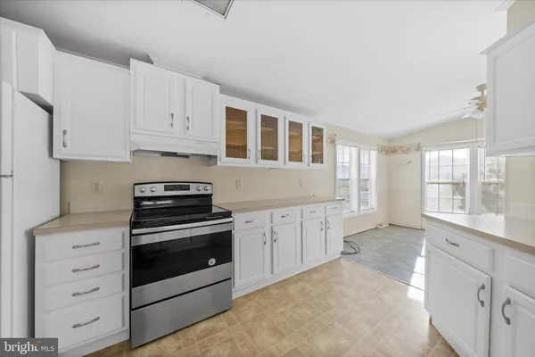 a kitchen with granite countertop white cabinets and appliances