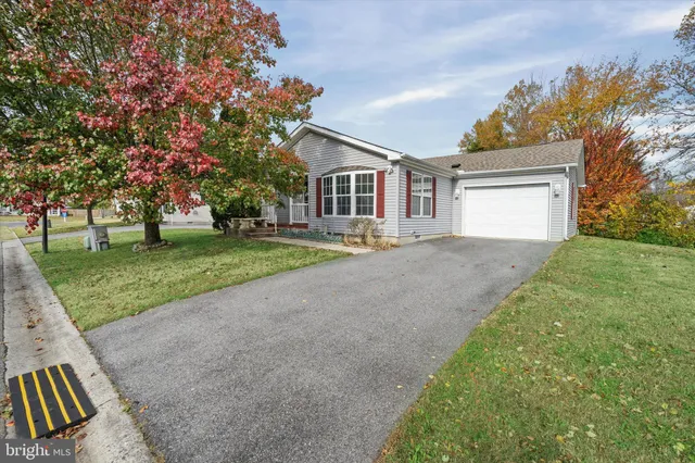 a front view of a house with a garden and trees