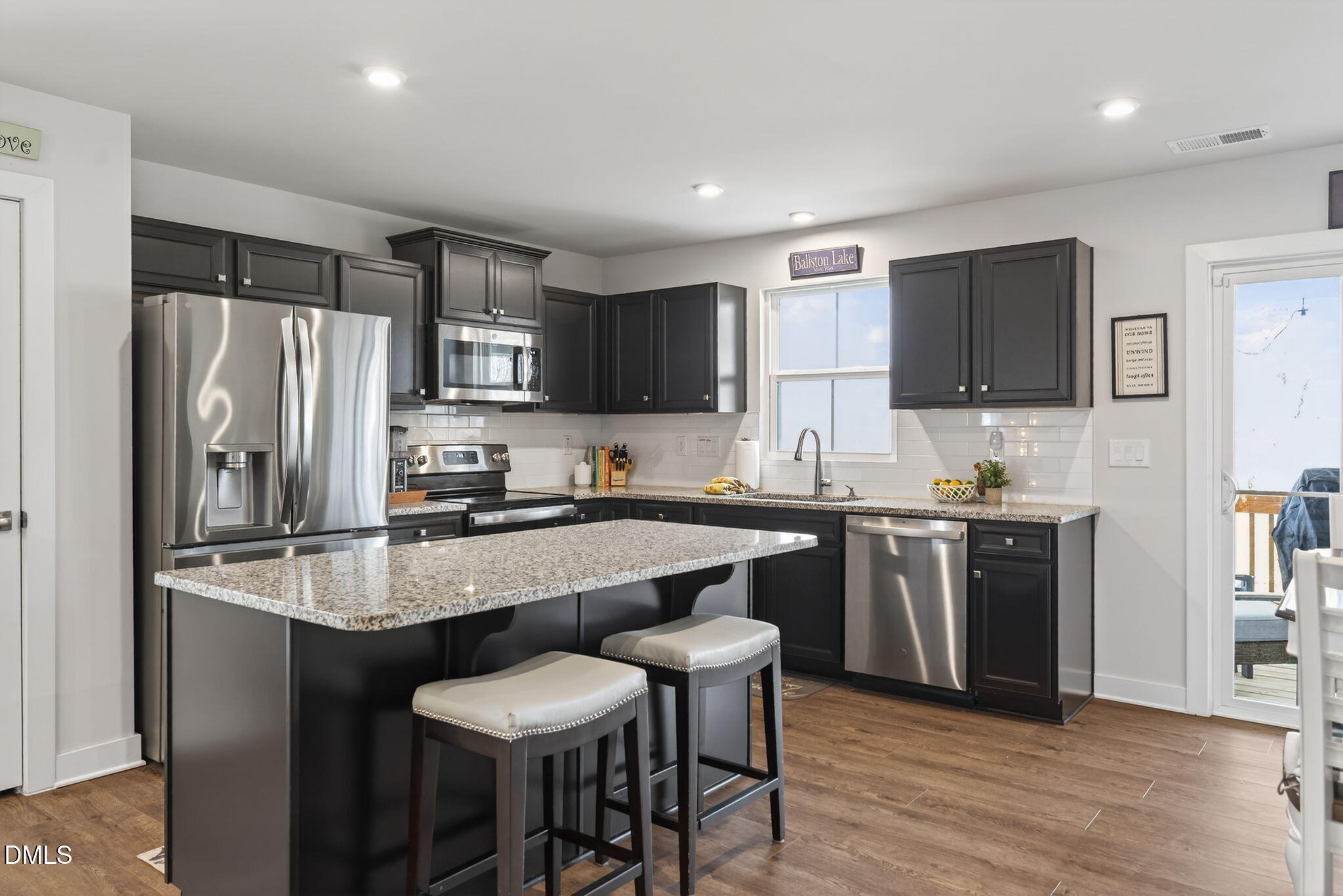 636 Jasmine Street Wendell, NC 27591 - Photo 10 of 30 a kitchen with stainless steel appliances granite countertop a refrigerator a stove a sink a dining table and chairs