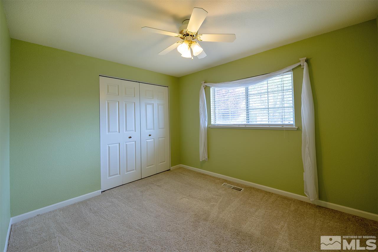 128 Empire Road Dayton, NV 89403 - Photo 12 of 20 an empty room with a ceiling fan and window