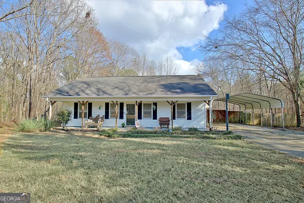 a front view of house with yard and trees around