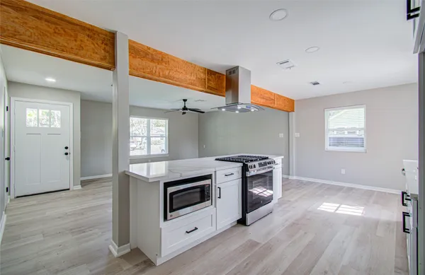a kitchen with a stove and a wooden floor