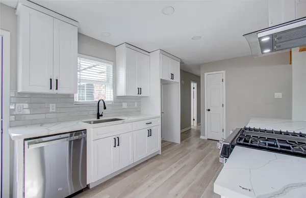 a kitchen with white cabinets and appliances