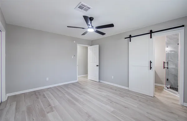 a view of an empty room with wooden floor